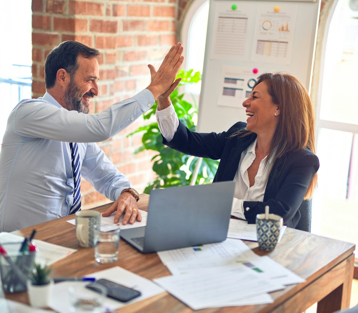 Two business partners celebrating marketing results together